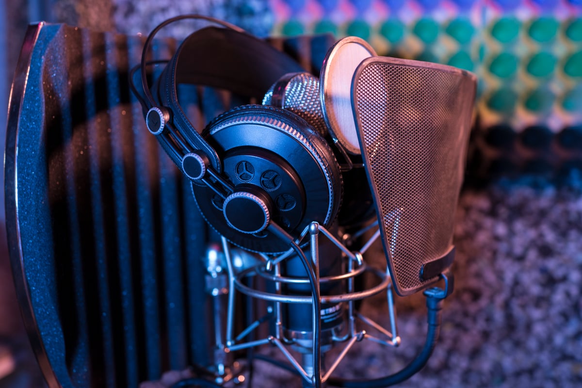 Studio headphones hanging on a microphone in blue and violet light